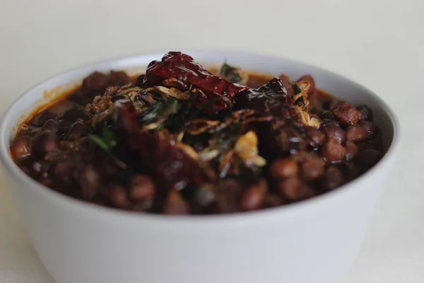 Black chickpeas curry prepared by chickpeas cooked with onions, tomatoes and spices. It is also known as kadala curry in southern parts of India.