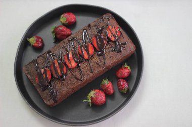 Parmak darı çikolatalı pasta. Çikolata sosu ve çilek ile süslenmiş, çok amaçlı un yerine parmak darı unundan yapılmış sağlıklı bir ev yapımı çikolatalı kek..