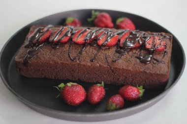 Parmak darı çikolatalı pasta. Çikolata sosu ve çilek ile süslenmiş, çok amaçlı un yerine parmak darı unundan yapılmış sağlıklı bir ev yapımı çikolatalı kek..