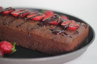 Parmak darı çikolatalı pasta. Çikolata sosu ve çilek ile süslenmiş, çok amaçlı un yerine parmak darı unundan yapılmış sağlıklı bir ev yapımı çikolatalı kek..