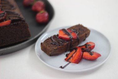 Parmak darı çikolatalı pasta. Çikolata sosu ve çilek ile süslenmiş, çok amaçlı un yerine parmak darı unundan yapılmış sağlıklı bir ev yapımı çikolatalı kek..