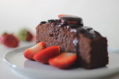Parmak darı çikolatalı pasta. Çikolata sosu ve çilek ile süslenmiş, çok amaçlı un yerine parmak darı unundan yapılmış sağlıklı bir ev yapımı çikolatalı kek..