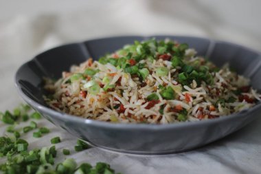 Kızarmış pirinç, evde pişirilmesi kolay bir Çin yemeği. Çiçek şeklinde gri bir kasede servis edilmiş. Beyaz arkaplanda çekilen