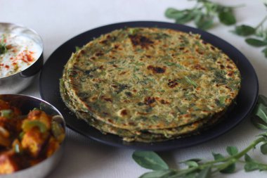 Tam buğday, metimethepla, paneer capsicum dolgulu ve bir kase masala peyniri. Sağlıklı, lezzetli, tam buğday, baharat, yoğurt, susam tohumu ve çemen yaprağından yapılmış bir düz ekmek..