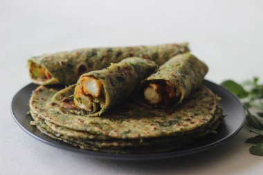 Tam buğday, metimethepla, paneer capsicum dolgulu ve bir kase masala peyniri. Sağlıklı, lezzetli, tam buğday, baharat, yoğurt, susam tohumu ve çemen yaprağından yapılmış bir düz ekmek..