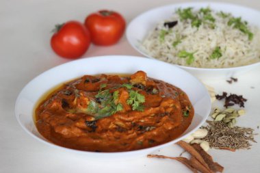 Bol domates soslu süzme peynir küpleri, kaju fıstığı, kimyon ve baharatlı buğulanmış basmati pirinci ile servis edilen baharatlar. Jeera pilavlı tereyağlı paneer