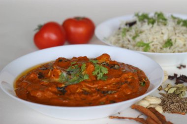 Bol domates soslu süzme peynir küpleri, kaju fıstığı, kimyon ve baharatlı buğulanmış basmati pirinci ile servis edilen baharatlar. Jeera pilavlı tereyağlı paneer