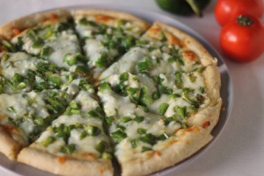 Peynirli ve biberli ev yapımı sebzeli pizza. Beyaz arkaplanda çekilen