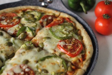 Peynirli domates ve dolmalık biberli ev yapımı sebzeli pizza. Beyaz arkaplanda çekilen