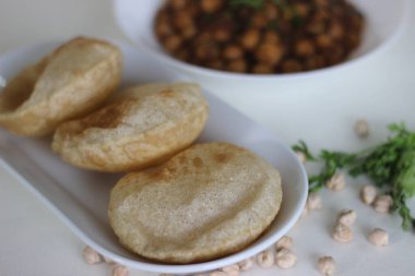 Tüylü tam buğday ekmeği ve yanında baharatlı nohut sosu. Yerel olarak Chole puri olarak bilinir. Beyaz arkaplanda çekilen