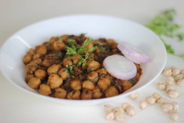 Nohutu bir gecede ıslatıp soğan, domates, zencefil, sarımsak ve baharat sosunda pişirilen baharatlı nohut sosu. Beyaz arkaplanda çekilen