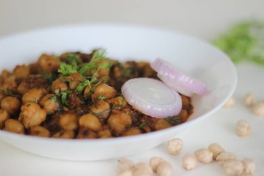 Nohutu bir gecede ıslatıp soğan, domates, zencefil, sarımsak ve baharat sosunda pişirilen baharatlı nohut sosu. Beyaz arkaplanda çekilen