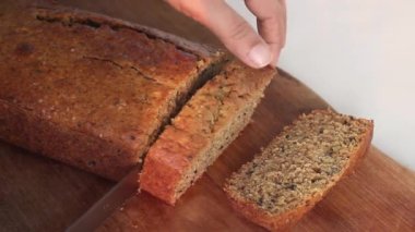 Evde tam pişmiş buğday olgun muzlu kek dilimliyorum. Ayrıca olgun muz ekmeği olarak da bilinir. Beyaz bir arkaplanda çekilmiş.