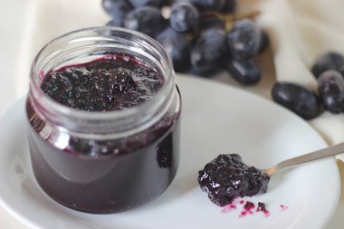 Üç malzemeli ev yapımı üzüm reçeli çekirdeksiz siyah üzüm, şeker ve limon suyu. Beyaz arkaplanda çekilen