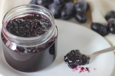 Üç malzemeli ev yapımı üzüm reçeli çekirdeksiz siyah üzüm, şeker ve limon suyu. Beyaz arkaplanda çekilen