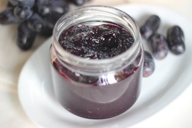 Üç malzemeli ev yapımı üzüm reçeli çekirdeksiz siyah üzüm, şeker ve limon suyu. Beyaz arkaplanda çekilen