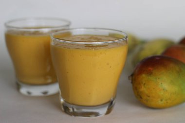 Mango Muz Smoothie, mango aromalı lezzetli ve kremalı muzlu smoothie. Sadece 5 basit malzemeyle yapıldı. Beyaz arkaplanda çekilen