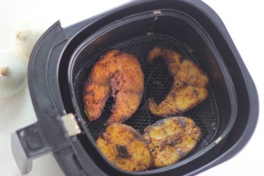 Cobia fish inside the air fryer. In India it is called Moda fish. Other common names include black kingfish, black salmon, ling, lemonfish, crabeater, prodigal son and black bonito. Shot on white background clipart
