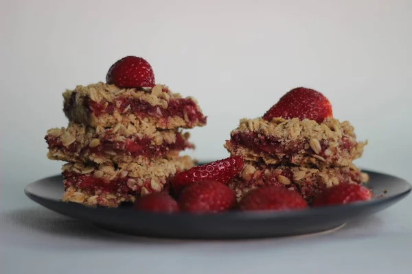 Homemade strawberry oats bar with fresh strawberries and rolled oats. Shot on white background