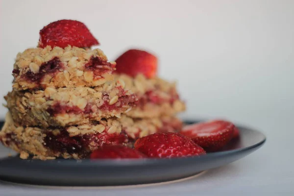 Homemade strawberry oats bar with fresh strawberries and rolled oats. Shot on white background