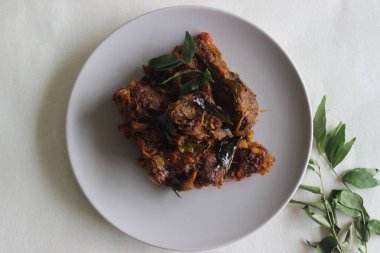 Hindistancevizi yağıyla hazırlanmış Kerala usulü koyun rostosu. Beyaz arkaplanda çekilen