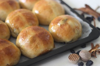 Taze pişmiş haçlı çörekler. Tarçın ve hindistan cevizi ile hafif baharatlı ve üzerinde haç bulunan bir tatlı meyve çöreği Kutsal Cuma günü servis edilir. Bu gelenek tüm dünyada Kutsal Cuma ile ilişkilendirilir.