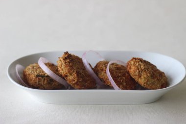 Açık kahverengi tavuk pirzolası, tavuklu kızartma makinesinde yapıldı. Beyaz arkaplanda çekilen