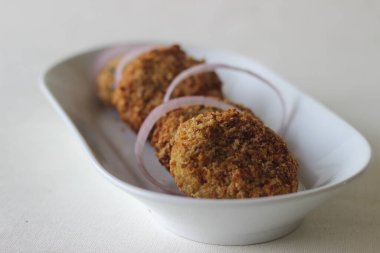 Açık kahverengi tavuk pirzolası, tavuklu kızartma makinesinde yapıldı. Beyaz arkaplanda çekilen