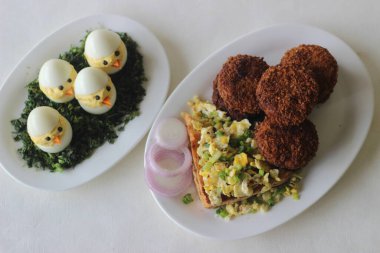 Tavuk pirzolası, ekmek, çırpılmış yumurta ve Paskalya yumurtası ile Paskalya kahvaltısı. Beyaz arkaplanda çekilen.