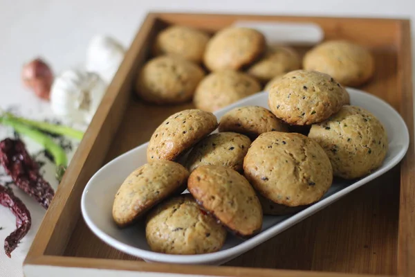 Home baked masala cookies. Sweet and spicy cookies with flavours of shallots, garlic, cinnamon, cardamom, fennel seeds and other spices. Shot on white background.