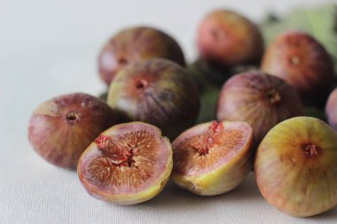 Olgun ve sulu taze incir bütün ve yarı yarıya. Beyaz arkaplanda çekilen.