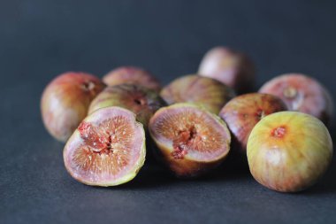 Olgun ve sulu taze incir bütün ve yarı yarıya. Siyah arkaplanda çekilen.