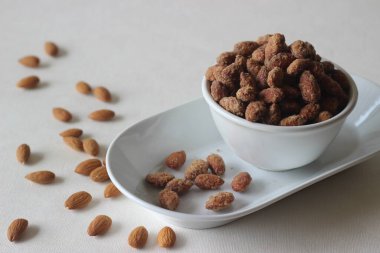 Kıtır kıtır ve kahverengi şekerli bademler. Beyaz arkaplanda çekilen.