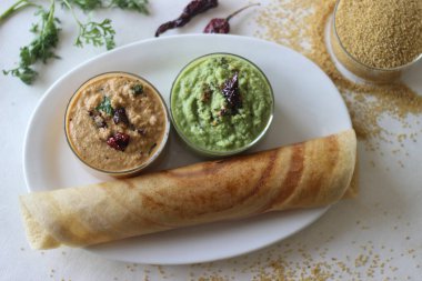 Mayalanmış tilki kuyruğu darı hamurundan yapılmış çıtır krep. Hindistan cevizi bazlı çeşitli baharatlarla servis edilmiş. Beyaz arkaplanda çekilen.