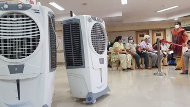 Mumbai, Maharashtra, Hindistan, 13 Nisan 2021: Covid 19 aşı merkezi olan bir hastanenin bekleme alanında kullanılan hava soğutucusu. Geniş bir açık alanı soğutmak için kolay bir yol sunuyor. Hindistan 'da popülerdir.