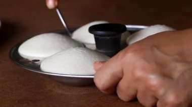 Tabaktaki küften yerel olarak Idli olarak bilinen tuzlu pirinç kekini çıkarıyorum. Idli mayalanmış pirinç hamuru buharı ile hazırlanır.. 