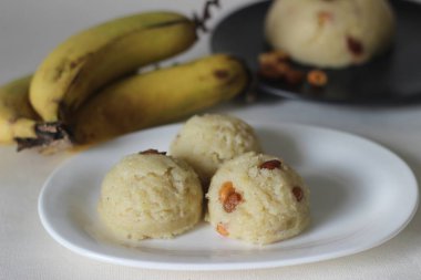 Semolina muzlu pudingi. Semolina, ghee, şeker, muz ve kaju fıstığıyla süslenmiş yumuşak bir Hint pudingi. Muz kılıfı olarak da bilinir. Beyaz arkaplanda çekilen