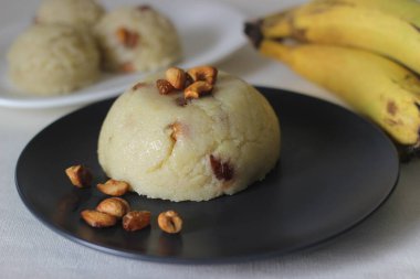 Semolina muzlu pudingi. Semolina, ghee, şeker, muz ve kaju fıstığıyla süslenmiş yumuşak bir Hint pudingi. Muz kılıfı olarak da bilinir. Beyaz arkaplanda çekilen