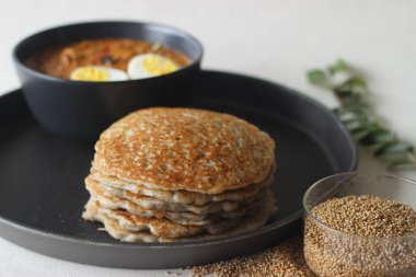 Yumurta rostoyla servis edilen Kodo darı krepleri. Krep mayalanmış kodo darı hamuru, düzleştirilmiş pirinç ve hindistan cevizi ile yapılır. Yumurta rostosu, baharatlı soğan, domates ve baharat soslu haşlanmış yumurtadır.