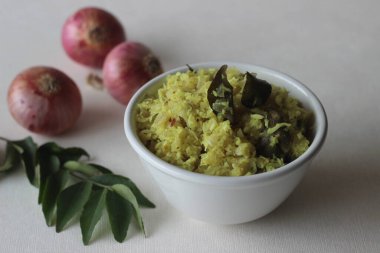 Kızarmış soğanı rendelenmiş hindistan cevizi, yeşil biber ve köri yapraklarıyla karıştır. Kerala yemekleri için lezzetli bir meze. Beyaz arkaplanda çekilen.