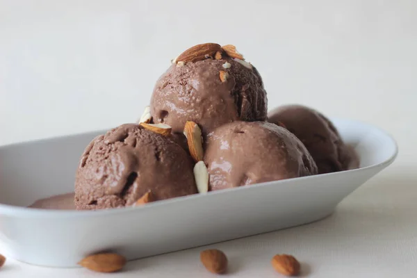 自家製のチョコレートアイスクリームのスクープは みじん切りアーモンドで提供しています 白地に撃たれた — ストック写真