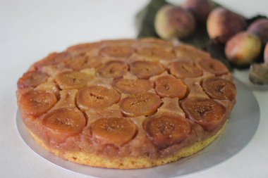 Taze incirli ve taze portakal suyuyla tatlandırılmış incirli baş aşağı bir pasta. Beyaz arkaplanda çekilen