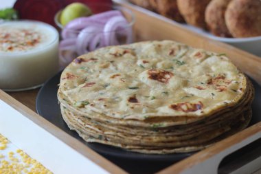 Kepekli ve mercimekli yüksek proteinli Hint düz ekmeği. Hindistan 'ın birçok yerinde moong dal paratha olarak bilinir. Vejetaryen pancar pirzolasıyla servis ediliyor. Beyaz arkaplanda çekilen.