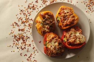 Doldurulmuş dolma dolma biber. Üzerine mozzarella peyniri serpiştirilmiş sotelenmiş süzme peynir ve havuç karışımıyla doldurulmuş çan biberlerinin havada kızartılmasıyla yapılır. Beyaz arkaplanda çekilen.