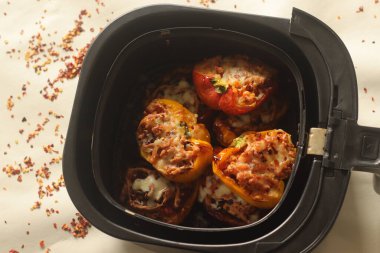 Havadan yapılan dolma dolma dolma dolmalık biberler baharatlı süzme peynir ve havuç karışımıyla doldurulmuş, üstüne mozzarella peyniri serpiştirilmiş. Fritözün içinde vurulmuş..