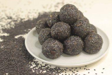 Geleneksel Hint tatlıları susam tohumları, jaggery ve hindistan cevizi ile yapılır, yaygın olarak Til ke laddu ya da susamlı ladoo olarak bilinir. Beyaz arkaplanda çekilen