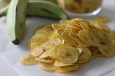 Kızarmış muz cipsi olgun muz dilimlerinin altında kızartılmış. Vejetaryen Onam yemeklerinin ana öğelerinden biri olan etakka upperi. Beyaz arkaplanda çekilen