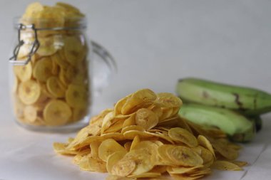 Kızarmış muz cipsi olgun muz dilimlerinin altında kızartılmış. Vejetaryen Onam yemeklerinin ana öğelerinden biri olan etakka upperi. Beyaz arkaplanda çekilen