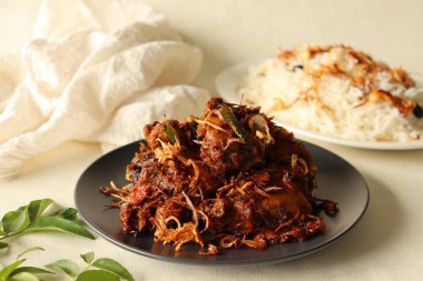 Kerala usulü baharatlı tavuk rostosu. Kızarmış soğan ve kaju fıstığı ile süslenmiş basmati pilavından yapılmış ghee pilavı ile servis ediliyor. Kerala 'dan Ney Choru ve Kozhi Varuthathu adında popüler bir yemek kombinasyonu.