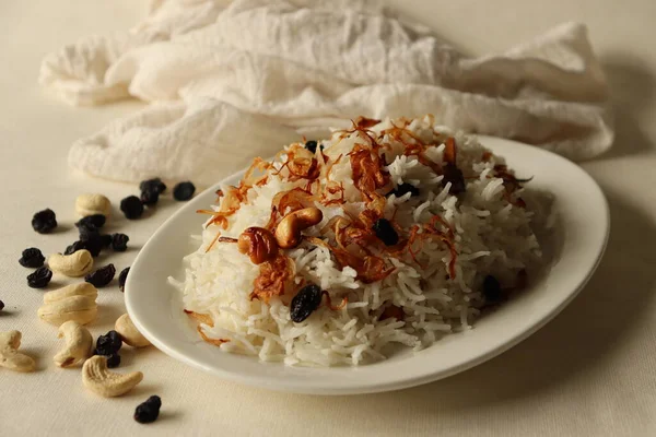 Rice dish made of Basmati rice, ghee and spices and garnished with fried onions and cashews. Commonly known as Ney choru in Kerala. Shot on white background.